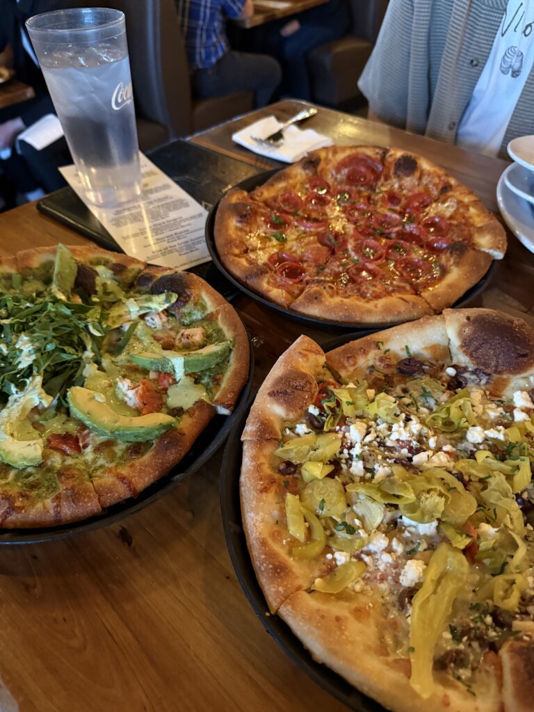 3 pizza pies with several toppings