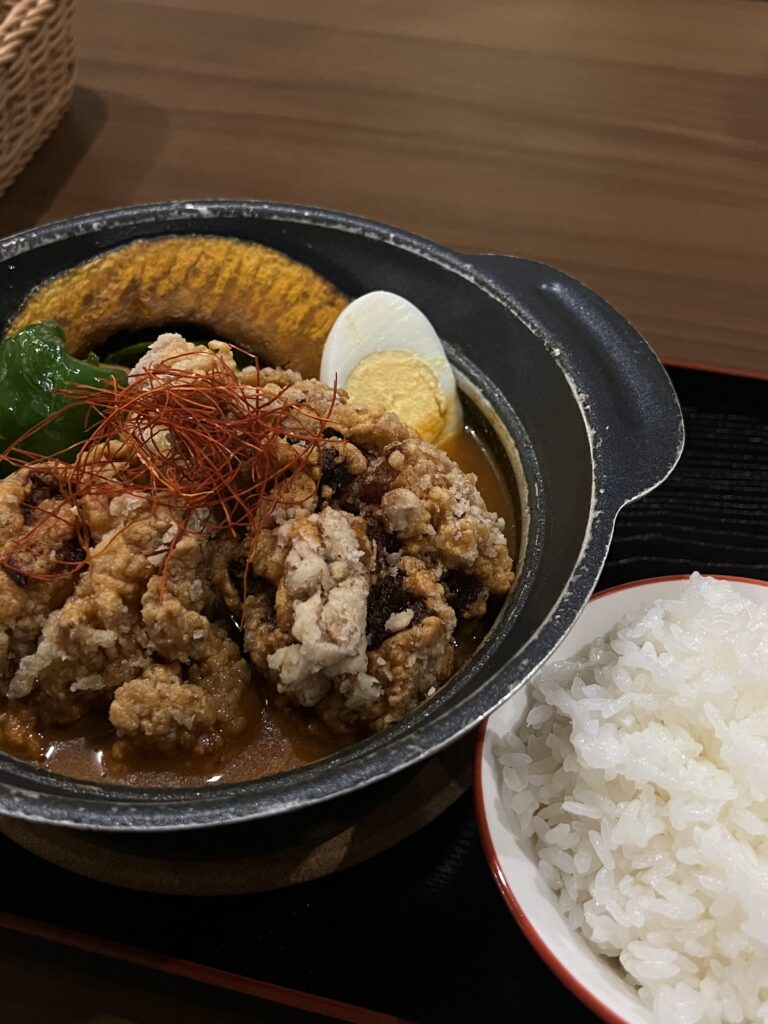 close up of chicken katsu curry in bowl next to rice