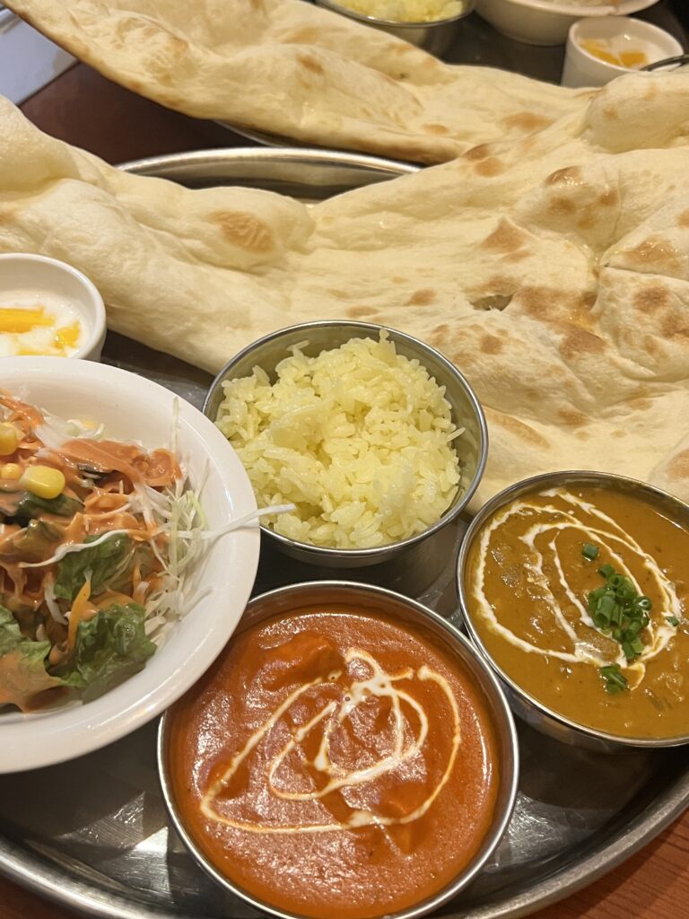 naan, curry, and rice in small bowls next to each other