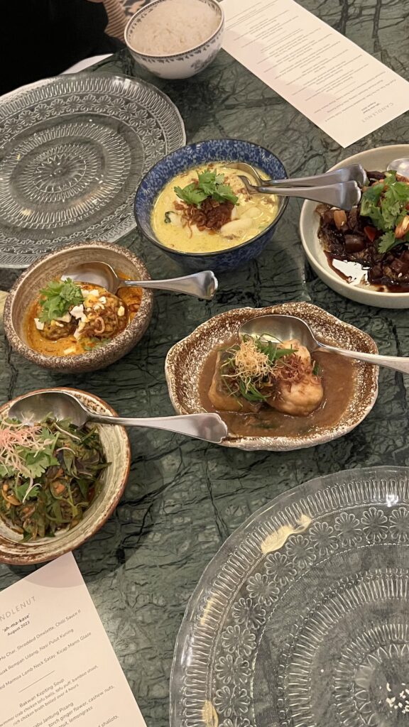 Multiple Peranakan dishes in bowls and plates on table