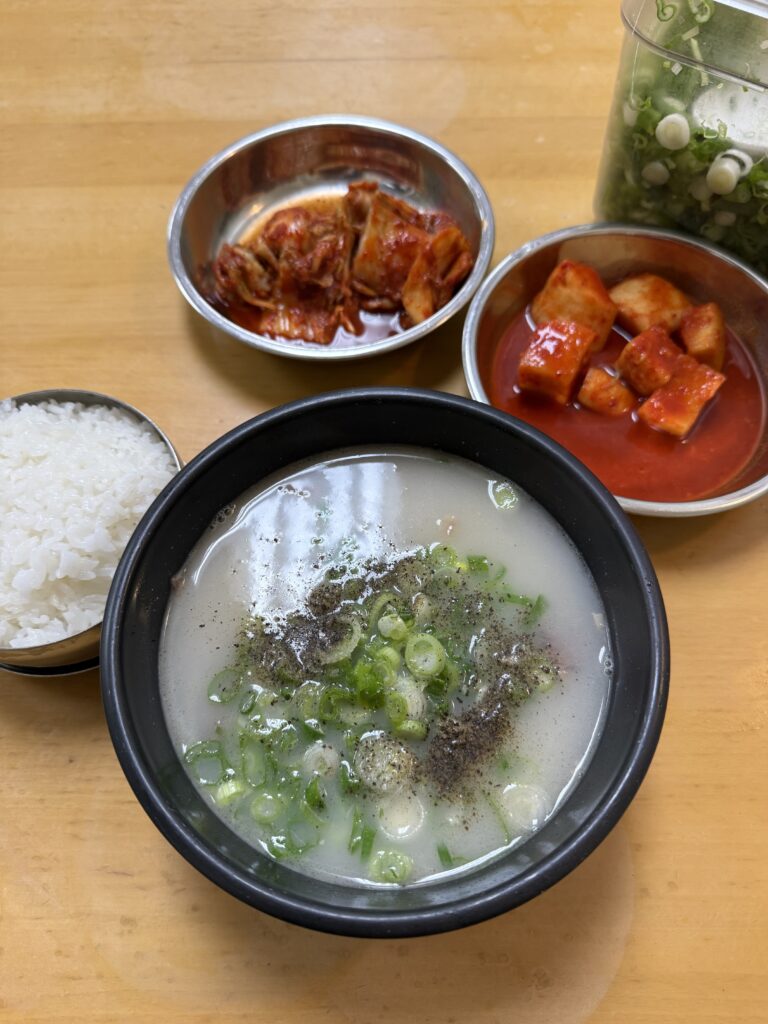 Korean ox tail soup in bowl next to kimchi and rice