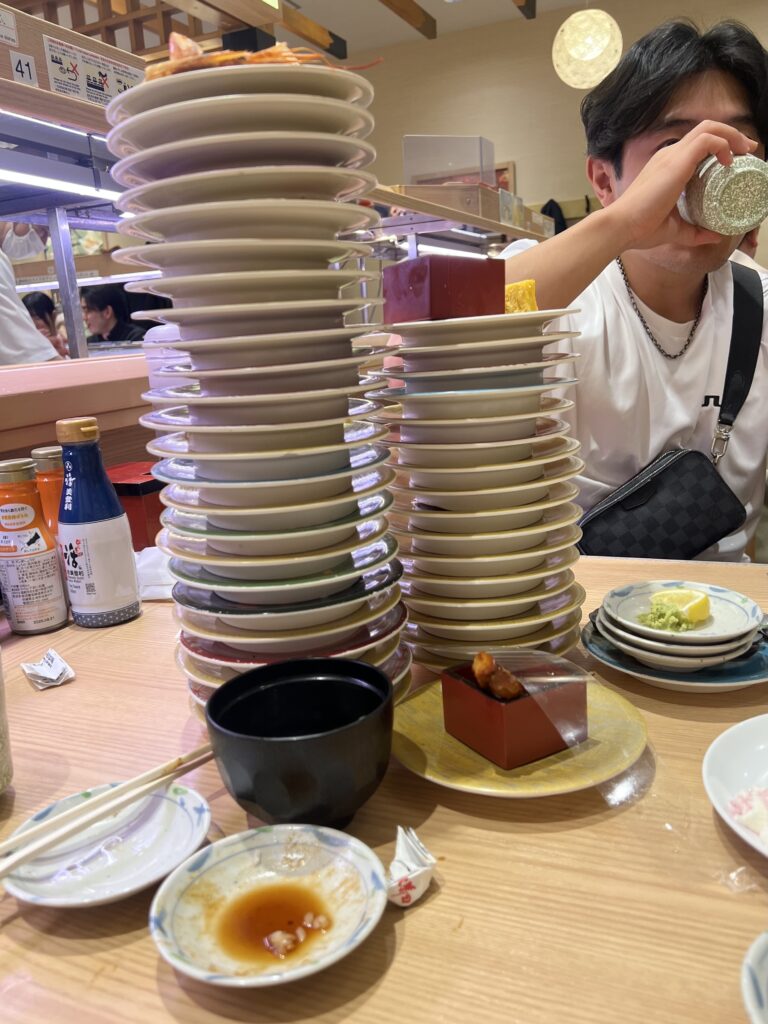 picture of conveyor belt sushi plates stacked up really high